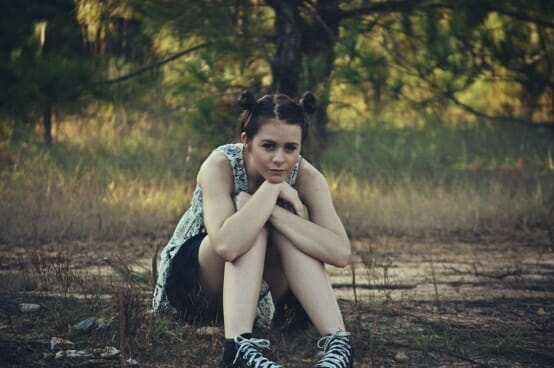 Teen girl sitting in a forest